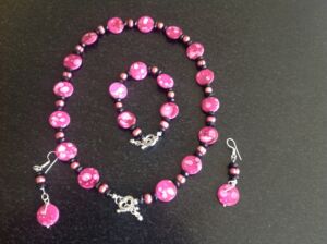 Pearl necklace, bracelet and earrings set Pink pearl and shell pearl necklace, bracelet and earring set. This can be ordered in different colours subject to availability. Price on application.
